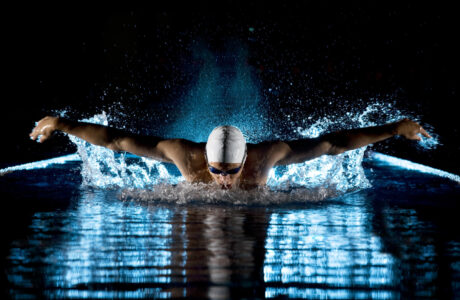Nuotatore durante un allenamento di nuoto a farfalla prende respiro fra un movimento e l'altro