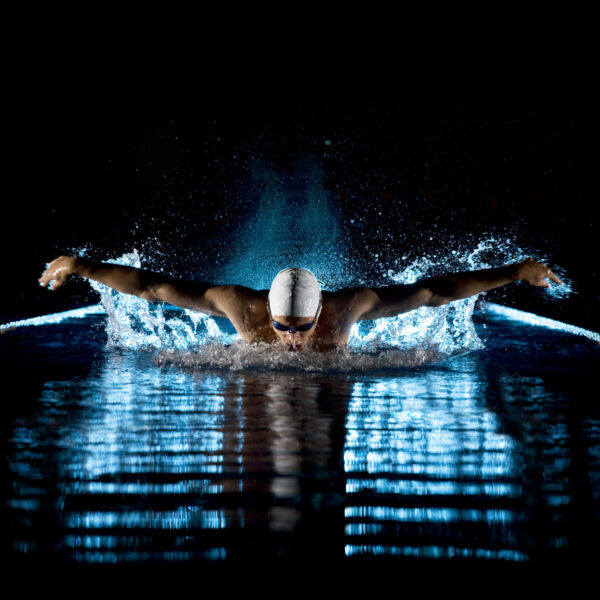 Nuotatore durante un allenamento di nuoto a farfalla prende respiro fra un movimento e l'altro