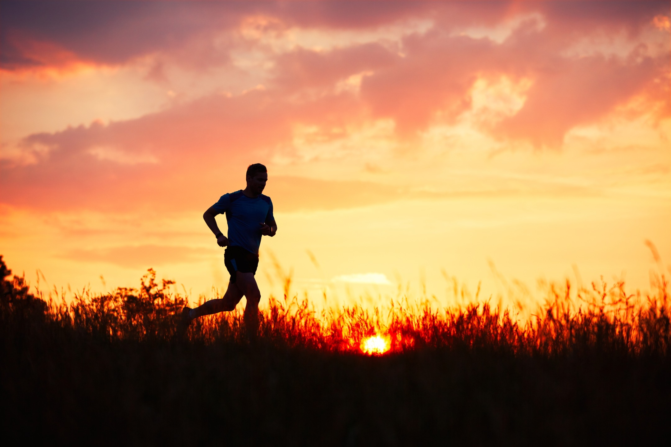Trail running: un circuito per allenare il fiato 1 Silhoutte di un ragazzo che corre al tramonto in un sentiero di trail running